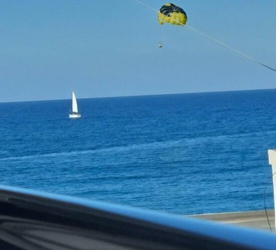 View of a sailboat on the calm blue sea near ELEANA Beach Suites.